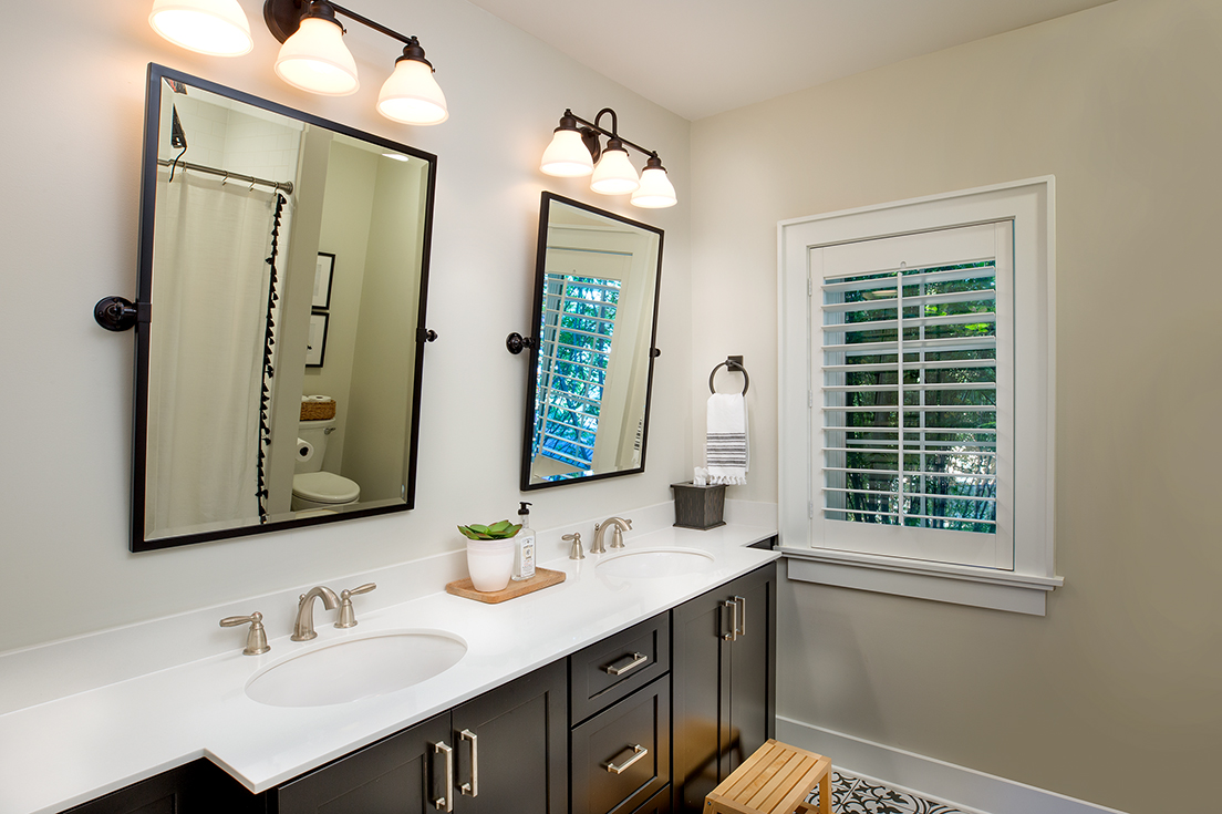 A bright, modern bathroom with double sinks and double mirrors. Renovation by Epic Group Ohio.